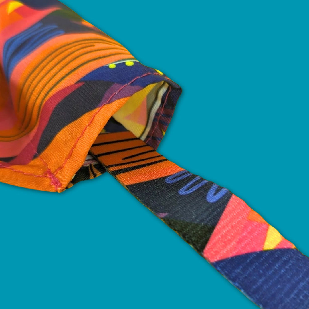 Très gros zoom sur le trou du bandana Panache pour chien avec un exemple de passage du collier