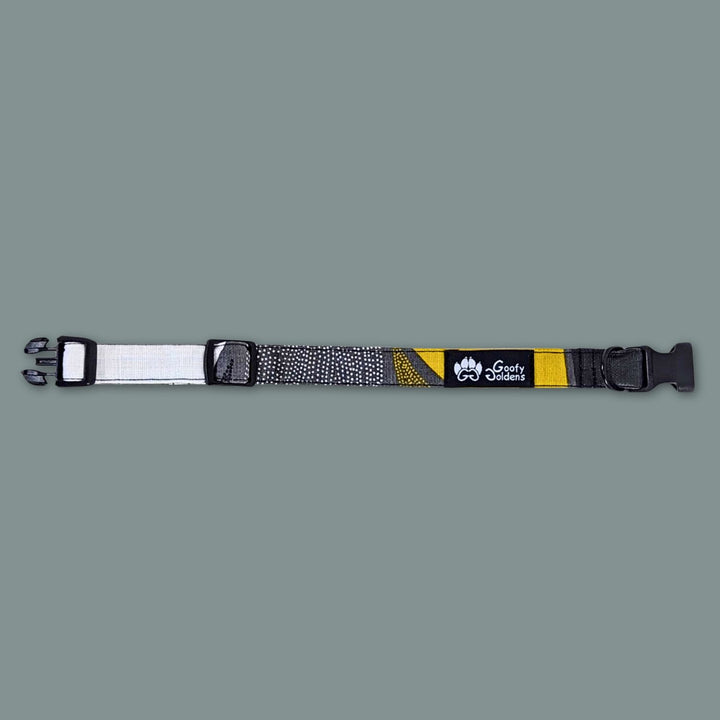 Joli collier chien tissu de la marque Goofy Goldens. Le collier est présenté ouvert et à plat pour distinguer les motifs et couleurs noir jaune et gris.
