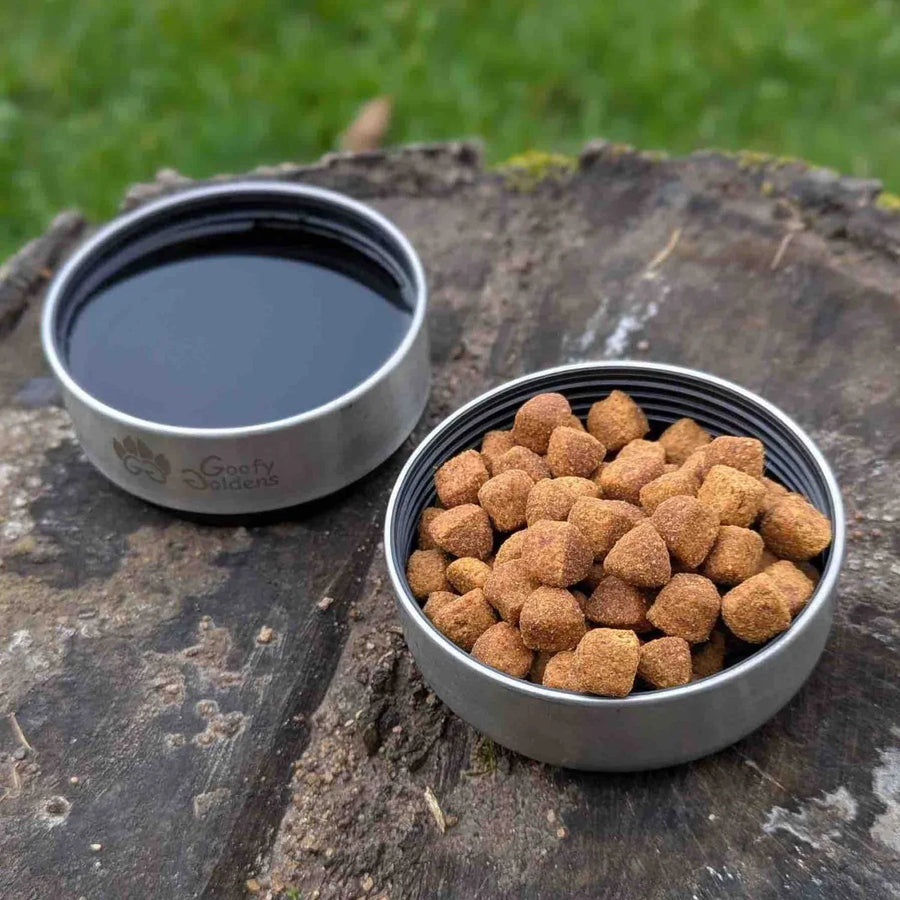 On distingue les deux bols en inox intĂ©grĂ©s Ă la gourde : lâun contenant de lâeau, lâautre des croquettes. Un des deux bols est dotĂ© du logo Goofy Goldens.