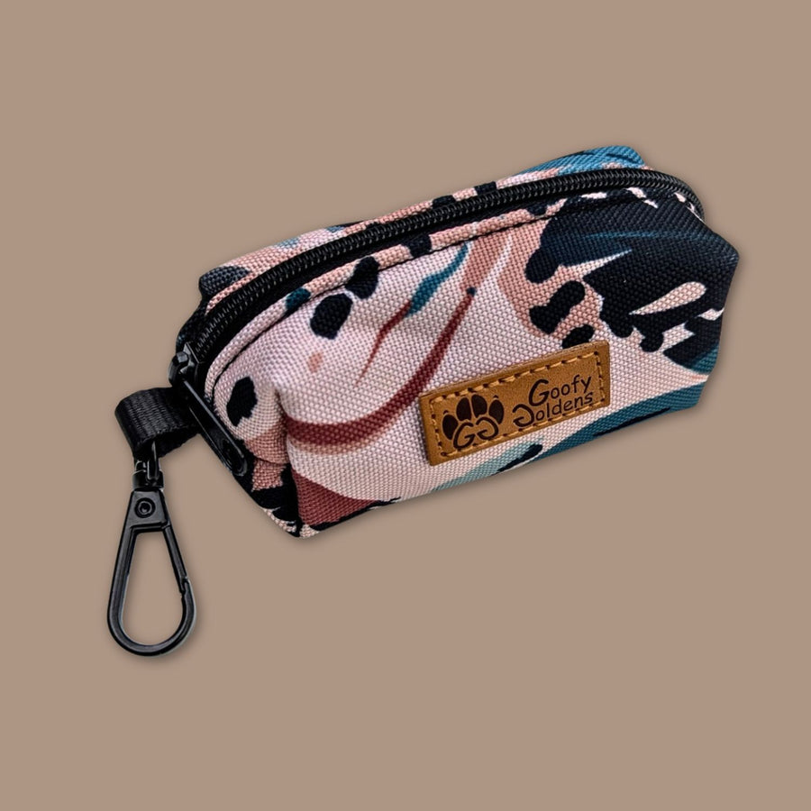 Distributeur de sacs à cacas/friandises Savane de la marque Goofy Goldens. Il présente une fermeture éclaire et un anneau en alliage pour pouvoir l’accrocher à la laisse.