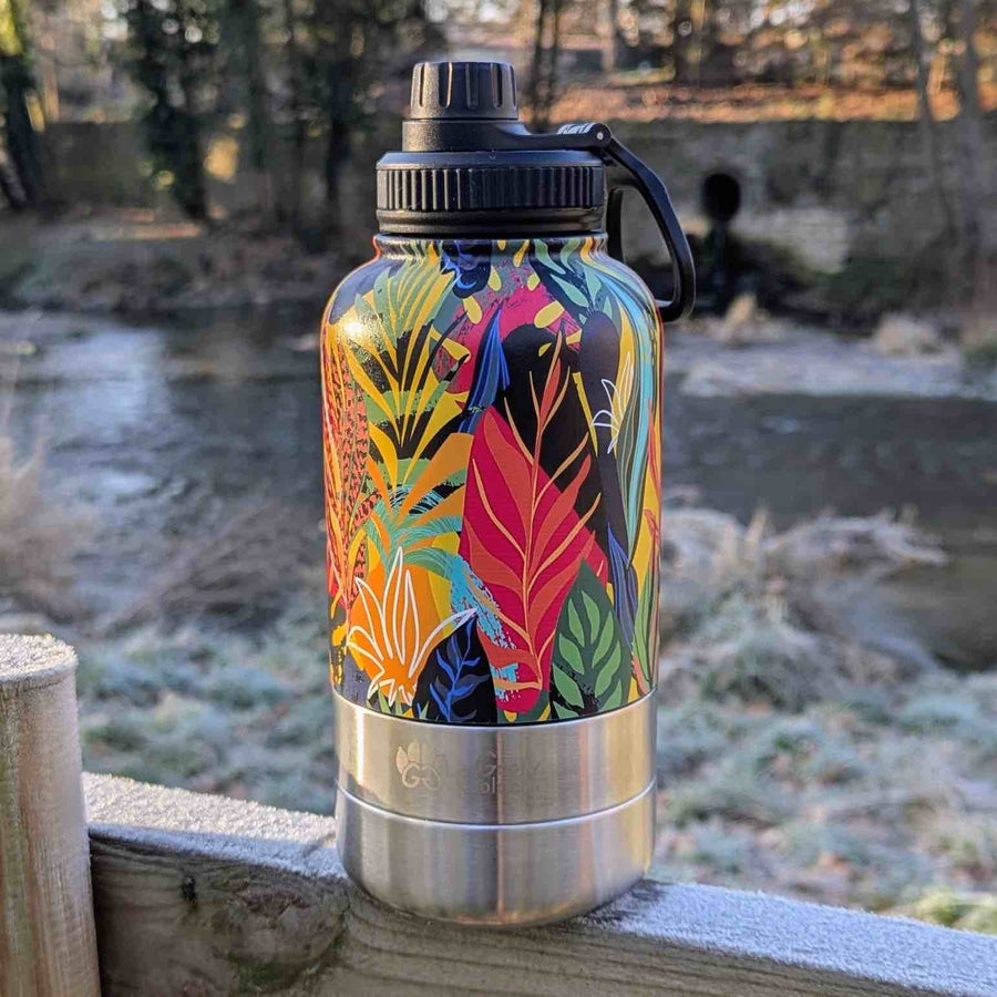 Gourde colorée 3-en-1 de la collection Tropical, posée sur une barrière gelée au bord de la rivière.