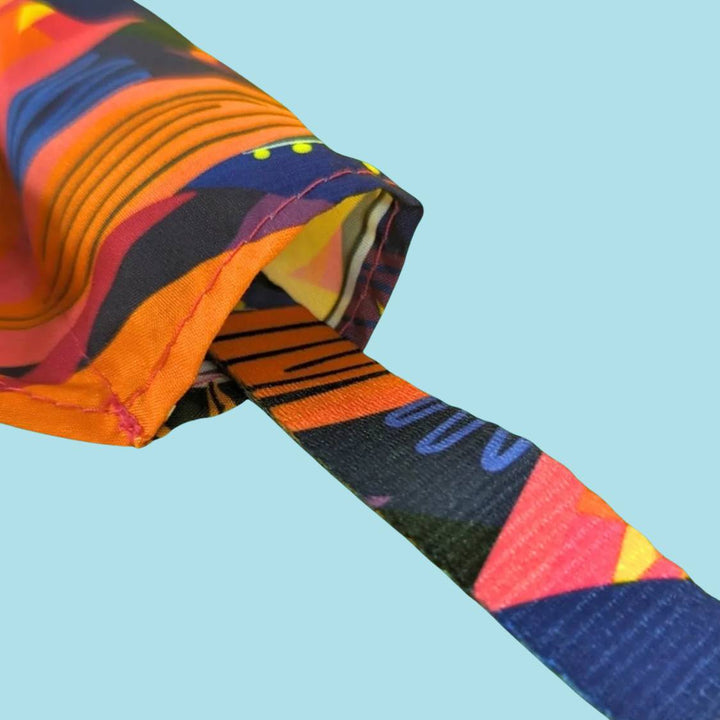 Très gros zoom sur le trou du bandana Panache pour chien avec un exemple de passage du collier 