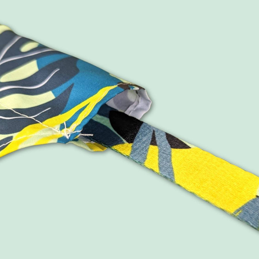 Très gros zoom sur le trou du bandana Récif pour chien original avec un exemple de passage du collier