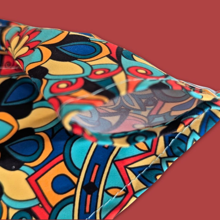 Zoom sur le passant du bandana Mandala aux couleurs vives de jaunes, bleus, verts et rouges.