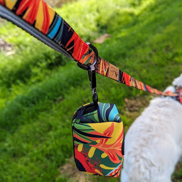 Photo d'un distributeur de sacs à cacas/friandises accroché à la laisse Tropical. Un moyen d'avoir toujours des sacs lors des balades.