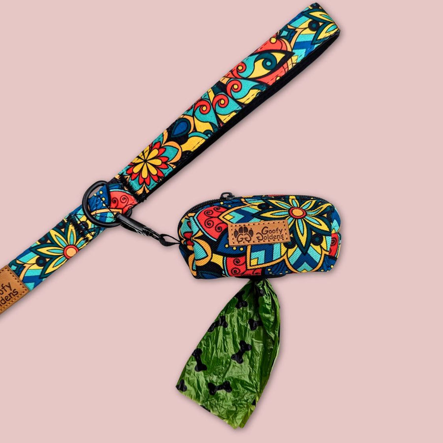 Mise en scène du distributeur de sacs à déjections Mandala : un sac apparaît par l'ouverture en caoutchouc prévu à cet effet, tandis que le distributeur est fixé à la laisse.