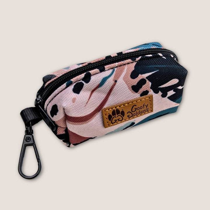 Distributeur de sacs à cacas/friandises Savane de la marque Goofy Goldens. Il présente une fermeture éclaire et un anneau en alliage pour pouvoir l’accrocher à la laisse.