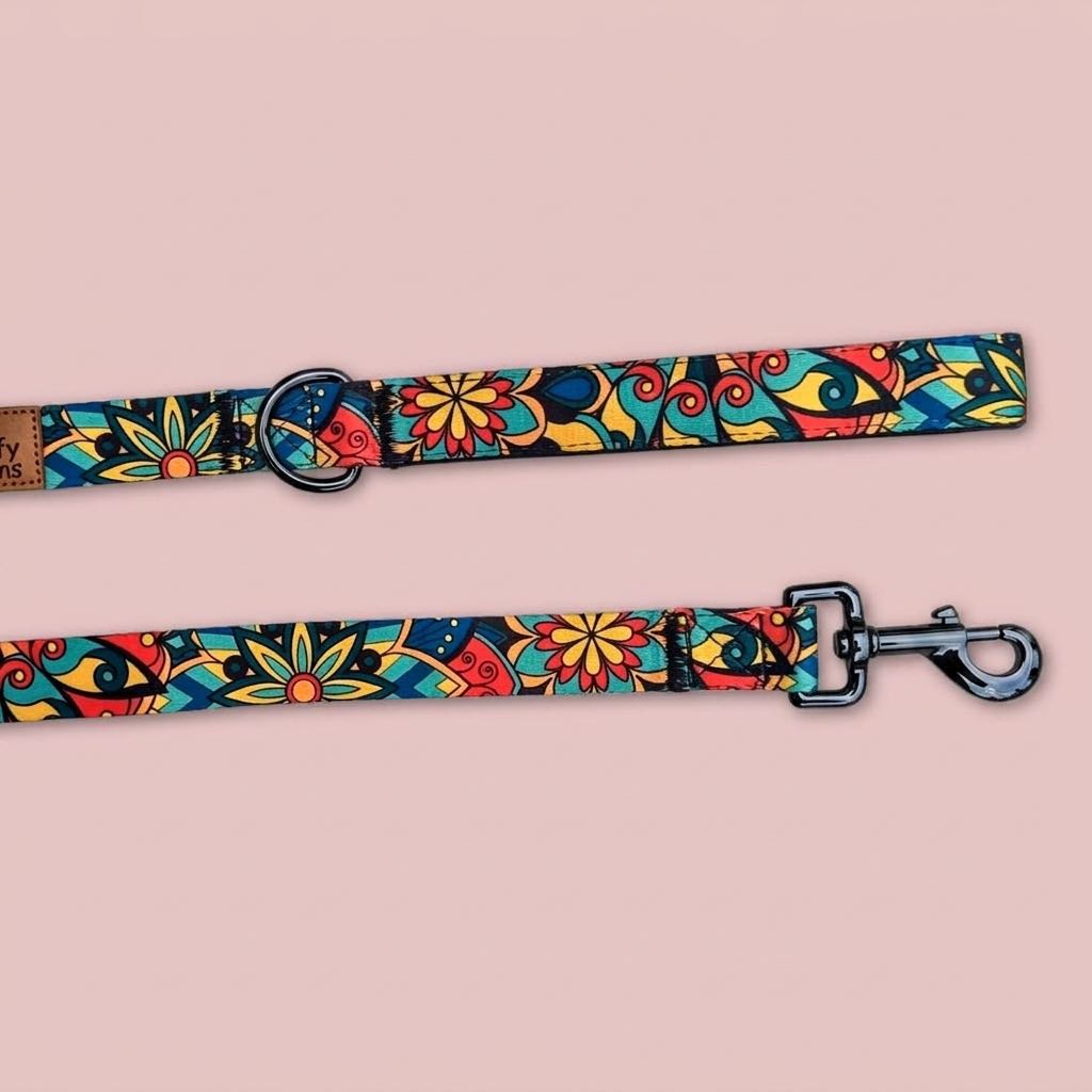 On aperçoit le mousqueton et le système d'attache de la laisse Mandala de la marque Goofy Goldens aux couleurs vertes, rouges, jaunes et bleues