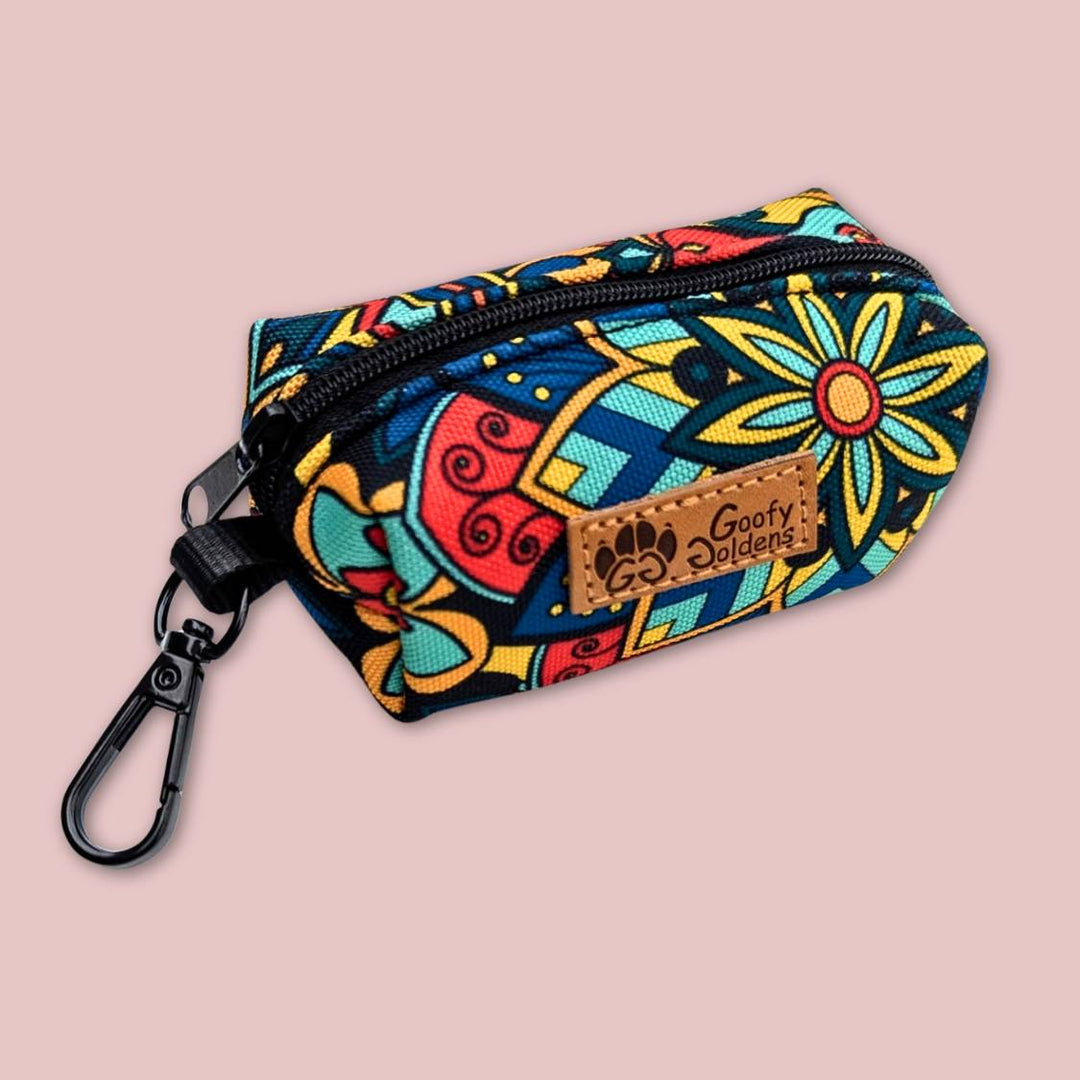 Photo d'un distributeur de sacs à déjections ou de friandises, orné de motifs mandala. Le produit se décline en rouge, vert, jaune et bleu. 