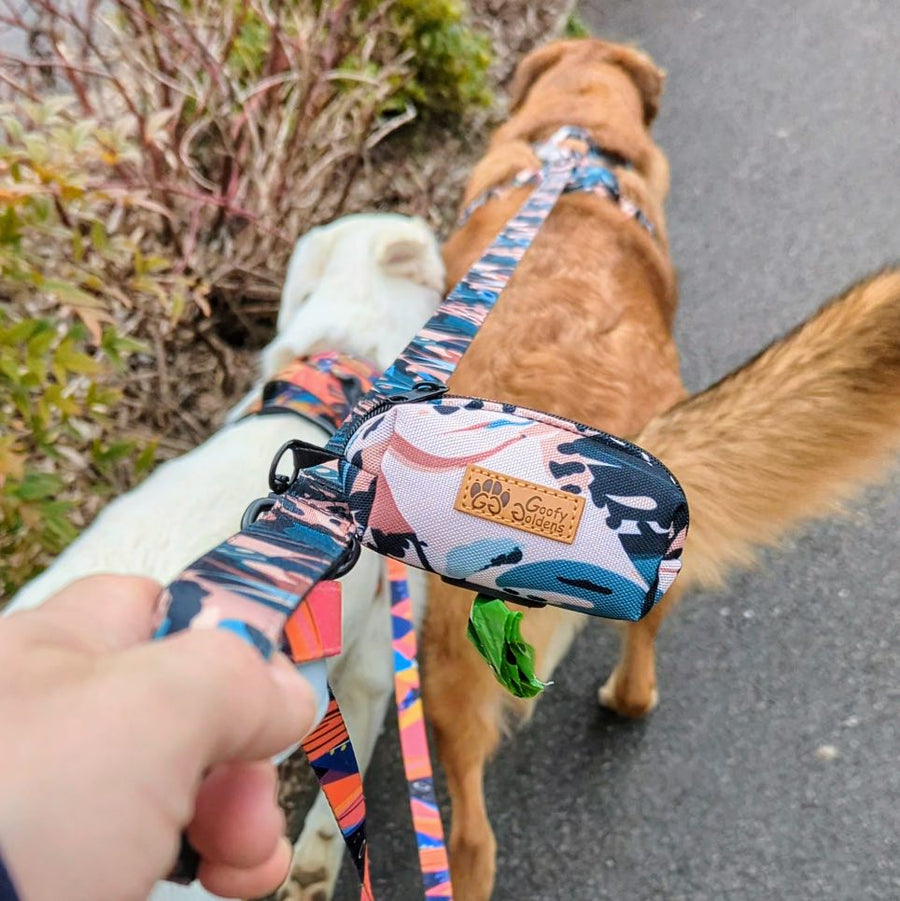 Gros plan sur la pochette de sacs à déjections, pratique et suspendue à la laisse du harnais anti-traction de la collection Savane, aux teintes marron, vert et beige.